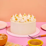 Classic Carrot Cake with smooth cream cheese icing topped with crystallised ginger, by Crumbs & Doilies.
